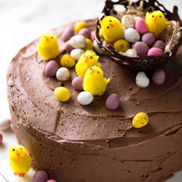 一个巧克力蛋糕和巧克力蛋糕，用了粉红色的玫瑰，而在小兔子床上的小羊羔。