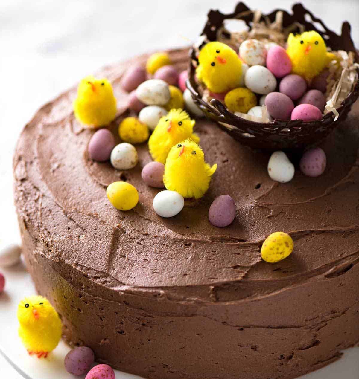 一个巧克力蛋糕和巧克力蛋糕，用了粉红色的玫瑰，而在小兔子床上的小羊羔。
